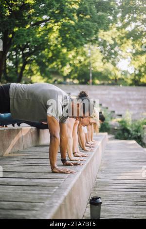 Seitenansicht von männlichen und weiblichen Freunden, die Liegestütze auf Stufen üben Stockfoto