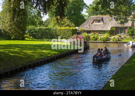 GIETHOORN, NIEDERLANDE - 05. AUGUST 2015: Unbekannte Besucher bei der Bootstour in einem Kanal in Giethoorn. Die schönen Häuser und Garde Stockfoto