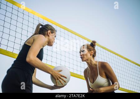 Niedrigwinkelansicht von Volleyballspielerinnen in Netznähe Stockfoto
