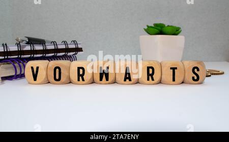 Buchstabenkombination mit Wort vorwärts in rotem Regal auf Holzhintergrund Stockfoto