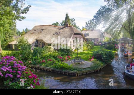 GIETHOORN, NIEDERLANDE - 05. AUGUST 2015: Unbekannte Besucher bei der Bootstour in einem Kanal in Giethoorn. Die schönen Häuser und Garde Stockfoto