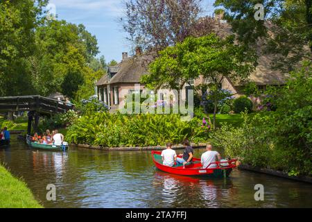 GIETHOORN, NIEDERLANDE - 05. AUGUST 2015: Unbekannte Besucher bei der Bootstour in einem Kanal in Giethoorn. Die schönen Häuser und Garde Stockfoto