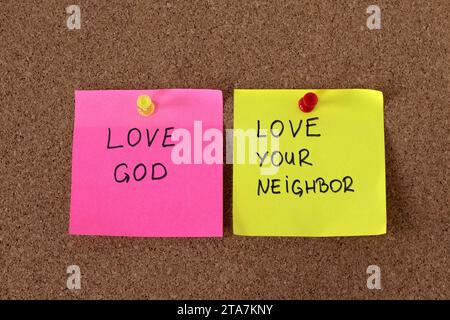 Liebe Gott, liebe deinen Nachbarn, handschriftliche Notizen auf Kork-Pinnbrett. Christlicher Gehorsam und glaube an Jesus Christus, das größte Gebot. Stockfoto
