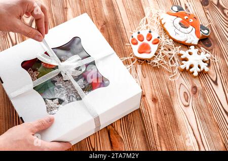 Die Hände eines Mannes öffnen ein Geschenk von einer Familie. Geschenke. Weihnachten Stockfoto