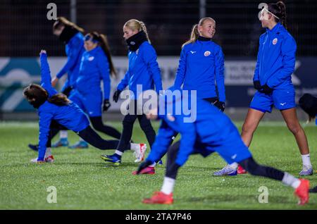 Rostock, Deutschland. November 2023. Die Hansa Rostock Spieler wärmen sich vor dem Training auf dem teilweise verschneiten Platz unter Flutlichtern auf. Nach 30 Jahren ohne Frauenmannschaft startet der bekannteste Fußballverein Mecklenburg-Vorpommerns in der Saison 2023/24 eine Frauen- und Mädchenabteilung. Hansa Rostocks Fußballerinnen haben in der laufenden Saison noch keinen Punkt verloren – die einzige Mannschaft in der Verbandsliga Mecklenburg-Vorpommerns, der höchsten Liga des Landes. Quelle: Jens Büttner/dpa/Alamy Live News Stockfoto