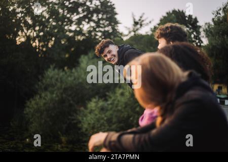 Verspielter Junge, der Spaß mit Freunden bei Sonnenuntergang hat Stockfoto