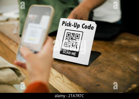 Hand Frau, die QR-Code über das Smartphone scannt, während sie online bezahlt Stockfoto