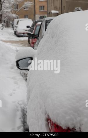 Gefrorenes Auto überdachter Schnee am Wintertag, Seitenfenster im verschneiten Waldhintergrund. Stockfoto