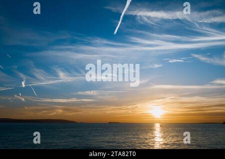 Sonnenuntergang über dem Solent mit Blick auf die Nadeln, Isle OF Wight und Hurst Castle mit Cirrus Uncinus, Mares Tail Clouds, Solent UK Stockfoto