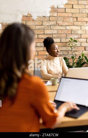 Zwei hübsche junge Geschäftsfrauen, die in einem modernen Büro arbeiten Stockfoto