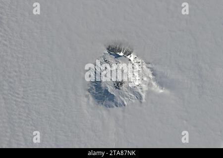 25. November 2023 – Antarktis – der Gipfelkrater des Mount Erebus, des südlichsten aktiven Vulkans der Welt, tauchte 2023 an einem späten Frühlingstag über den Wolken auf. Die OLI-2 auf Landsat 9 erfasste diese Ansicht des Stratovulkans am 25. November. Mount Erebus ist einer von mehreren Vulkanen, die Ross Island vor der Westantarktis bilden. Auf 3.794 Metern 12.450 über dem Meeresspiegel ragt er über dem nur 35 Kilometer entfernten Bahnhof McMurdo. Diese Vulkane treten in einer Bruchzone auf, in der sich die Kruste dünner ausdehnt und Magma durch Verwerfungen in die sur wanderte Stockfoto