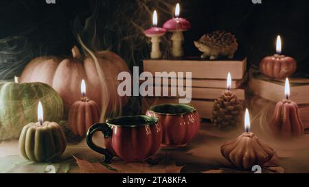 Süße Tassen Tee unter Kürbiskerzen. Herbstliche Inhalte, Café-Aktionen Stockfoto