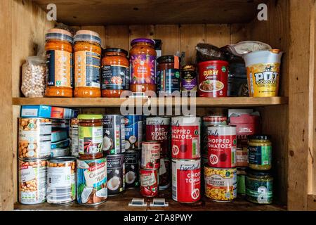 Eine hölzerne Speisekammer mit verschiedenen Dosenwaren und Saucen. Stockfoto