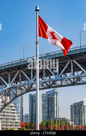 Kanadische Flagge mit Downtown Vancouver im Hintergrund. Die Lage ist Granville Island. Flagge von Kanada vor Blick auf False Creek und die Burrard Str. Stockfoto