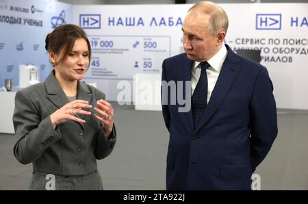 Sotschi, Russland. November 2023. Der russische Präsident Wladimir Putin, rechts, wird im Projekt Nasha LABA von der MIPT-Forscherin Elizaveta Mochalova, links, vor einem Treffen des Kongresses der jungen Wissenschaftler am 29. November 2023 in Sotschi gezeigt. Quelle: Mikhail Klimentyev/Kreml Pool/Alamy Live News Stockfoto