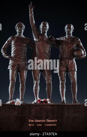 Trinity Statue von George Best, Bobby Charlton und Denis Law außerhalb von Manchester United FC at Night, Old Trafford, Manchester, UK Stockfoto