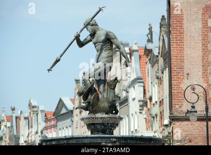 Der Blick auf den historischen Brunnen aus dem 17. Jahrhundert und die alten Stadthäuser von Danzig im Hintergrund (Polen). Stockfoto