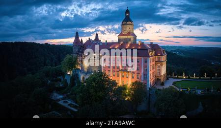 Abendlicher Blick auf das beleuchtete Schloss Ksiaz, Schloss Fürstenstein, eine wunderschöne Burg auf einem Felsen, umgeben von Wald in Niederschlesien Stockfoto