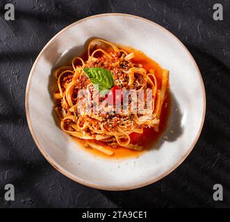 Köstliche Pasta in Bolognesesauce, mit Tomaten und grünem Basilikumblatt Stockfoto