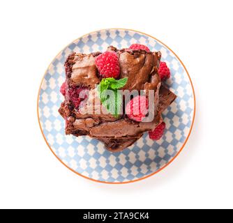 Teller mit Himbeer-Schokoladen-Brownie auf weißem Hintergrund Stockfoto