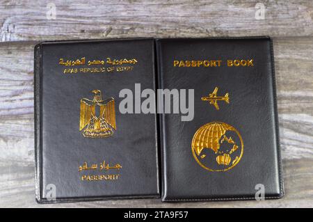 Ägyptischer Pass Schwarzes Buch, Übersetzung arabischer Wörter (Pass der Arabischen republik Ägypten) und Schwarzes Passbuch mit einem Flugzeug und der Erde Stockfoto