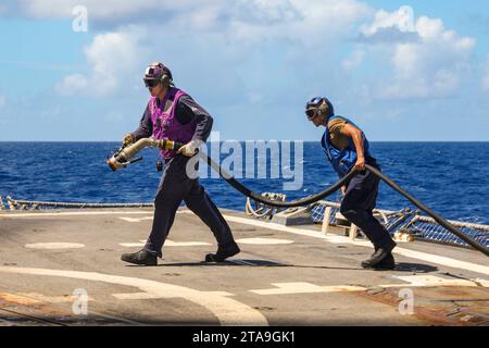 Philippinische See. November 2023. Gasturbinensystemtechniker (Elektrik) 2. Klasse Christopher Smart, links, aus Montrose, Colorado, und Seaman Cesar Bojorquez aus Oxnard, Kalifornien, bereiten sich darauf vor, einen MH-60R Sea Hawk zu tanken, der an die Warlords of Helicopter Maritime Strike Squadron (HSM) 51 angeschlossen ist, auf dem Flugdeck des Arleigh Burke-Klasse-Raketenzerstörers USS Shoup (DDG 86), während er Routineoperationen in der Philippinischen See durchführt. Shoup ist Commander, Task Force (CTF) 71/Destroyer Squadron (DESRON) 15, der größten DESRON der Marine und der DESRON Stockfoto