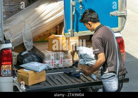 SAMUT PRAKAN, THAILAND, 18. NOVEMBER 2023, Kurier eines Paketdienstes transportiert Pakete zur Zustellung an die Zustelladresse Stockfoto