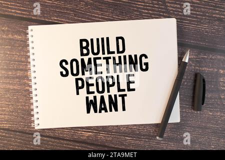 Bauen Sie etwas, was die Menschen wollen. Text auf weißem Notizblock auf Craft-Hintergrund. Stockfoto