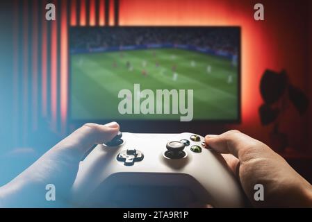 Mann, der Videospiele auf der Spielkonsole im Wohnzimmer spielt Stockfoto