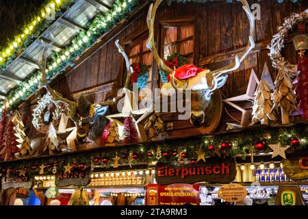 Glühwein Station mit den sprechenden Hirschen, die Gäste immer unterhalten - der Bonner Weihnachtsmarkt 2023 verwandelt die Innenstadt der Bundesstadt, wie hier auf dem Münsterplatz wieder in einer stimmungsvollen Budenstadt. Über 160 Stände bieten ein vielfältiges Angebot an kunsthandwerklichen und kulinarischen Köstlichkeiten. Der Markt ist vom 24. November bis zum 23. November. Dezember 2023 geöffnet. Bonn Innenstadt NRW Deutschland *** Glühweinstation mit dem sprechenden Hirsch, der die Gäste immer unterhalten wird der Bonner Weihnachtsmarkt 2023 wird die Innenstadt des Bundesstaats wieder verwandeln Stockfoto