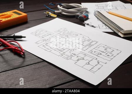 Schaltpläne, Büromaterial, Drähte und Digitalmultimeter auf Holztisch Stockfoto