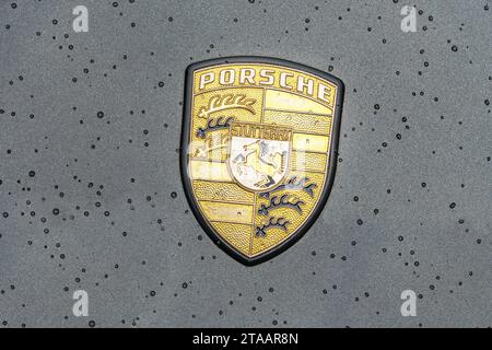 WETTENBERG, HESSEN, DEUTSCHLAND - 07 - 28 - 2023: Goldenes PORSCHE-Vintage-Symbol mit Regentropfen im Detail. Stockfoto