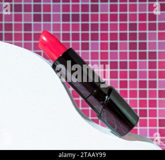 Eine Röhre roter Lippenstift im Badezimmer auf welligem abstrakten Hintergrund, Beauty and Cosmetics Nahaufnahme in Rot Stockfoto