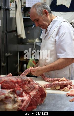 Ein Metzger, der frische Würste in seiner Metzgerei in San Telmo Market zubereitet. Buenos Airs. Argentinien Stockfoto