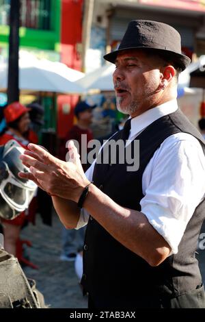 Ein männlicher Tangotänzer in traditionellem Outfit wartet darauf, dass ein Tourist mit ihm ein Foto macht, um Tipps zu erhalten in der Caminito Street.La Boca.Buenos Aries.Argentinien Stockfoto