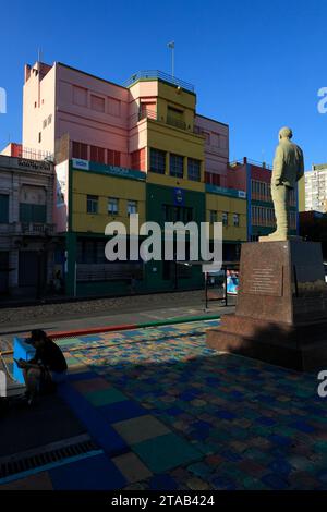 Die Statue von Benito Quinquela Martín am Fluss Riachuelo mit den bunten Gebäuden im Bezirk La Boca.Buenos Aires.Argentinien Stockfoto