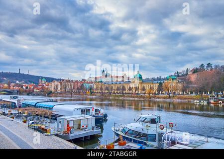 Moldau mit vertäuten Schiffen und Straka Academy am gegenüberliegenden Flussufer, Prag, Tschechien Stockfoto