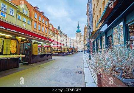 Die Straße von Havel Markt mit Pavillons, Outdoor Cafés, historischen Häusern und Glockentürmen der St. Havel Kirche im Hintergrund, Prag, Tschechische Republik Stockfoto