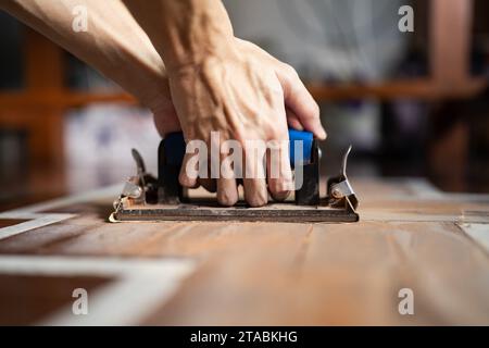 Schleifen von Holzböden mit Schleifpapierhalter Stockfoto