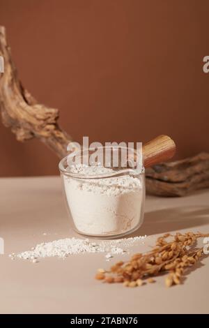 Reiskleiepulver in einer Glasschale mit Holzgriff gelagert. Lipide in Reiskleiepulver wirken antioxidativ und blockieren die Wirkung von Ultraviolett Stockfoto