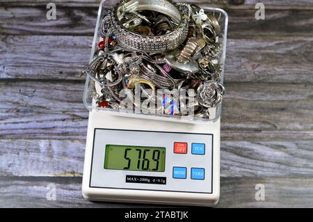 Stapel Silber auf einer digital genauen Skala in Gramm, Armbänder, Ringe und Silberketten, Goldpreiskonzept, Edelmetall, Einsparungen, Verkauf, b Stockfoto