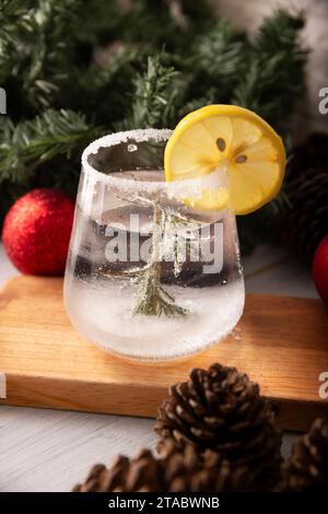 Schneekugel-Cocktail. Weihnachtsgetränk, kreatives Festgetränk im Glas, dekoriert mit Rosmarinzweig wie eine weihnachtskiefer und Zitrus sli Stockfoto