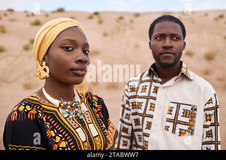 Modeporträt eines jungen afroamerikanischen Paares in traditioneller Kleidung, das zusammen in der Wüste posiert, Kopierraum Stockfoto