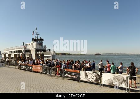 New York, USA - 24. Mai 2018: Leute warten auf die Fähre von Statue Cruises, um die Freiheitsstatue und Ellis Island zu besuchen. Stockfoto