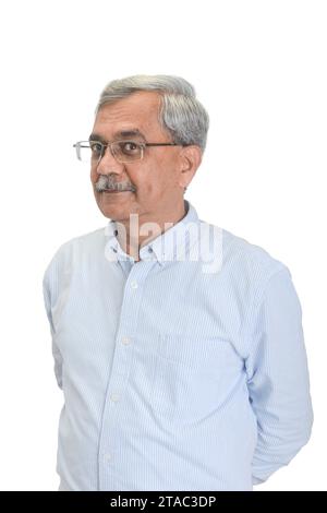 Ein lächelnder leitender indischer Geschäftsmann oder Executive mit grauen Haaren in einem hellblauen Hemd isoliert auf weiß Stockfoto