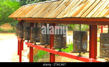 Gebetsmühle unter einem Holzdach im Garraf Sakya Tashi Ling Buddhistischen Tempel, Barcelona, Spanien. Ein Symbol für Spiritualität und Frieden Stockfoto