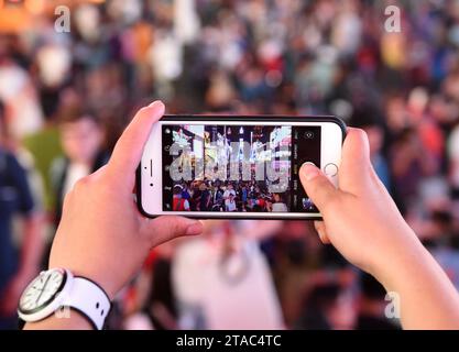 New York, USA - 10. Juni 2018: Eine Frau macht ein Foto auf seinem iPhone am Times Square in New York. Stockfoto