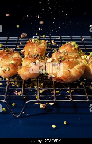 Süße Brötchen, bestreut mit Pistazien auf blauem Hintergrund. Stockfoto