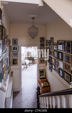 Bilderwand und Geländer im Flur eines Hauses in West London aus dem späten 19. Jahrhundert. Stockfoto