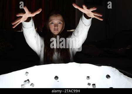 Teenager-Mädchen würfelt und wirft Würfel aus ihren Händen Stockfoto